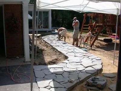 Quality Landscape crew setting a natural flagstone walkway on a prepared base